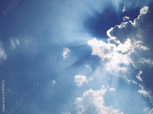 Light ray from sun behind cloud in the blue sky