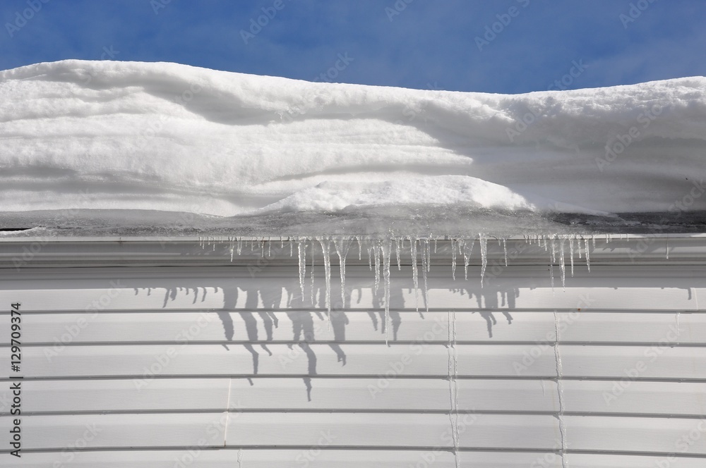 Thick snow and icicles in house roof