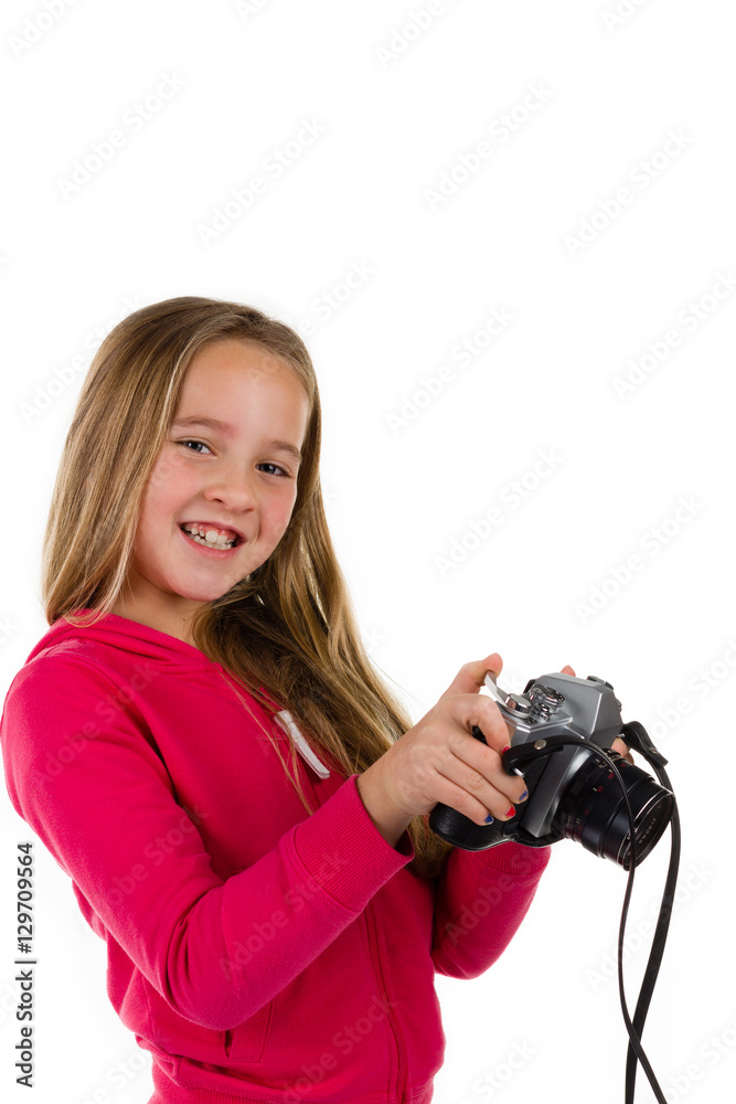 Young girl holding a vintage SLR camera laughing isolated on a white background