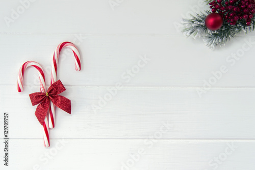 Candy canes and christmas tree branch on white