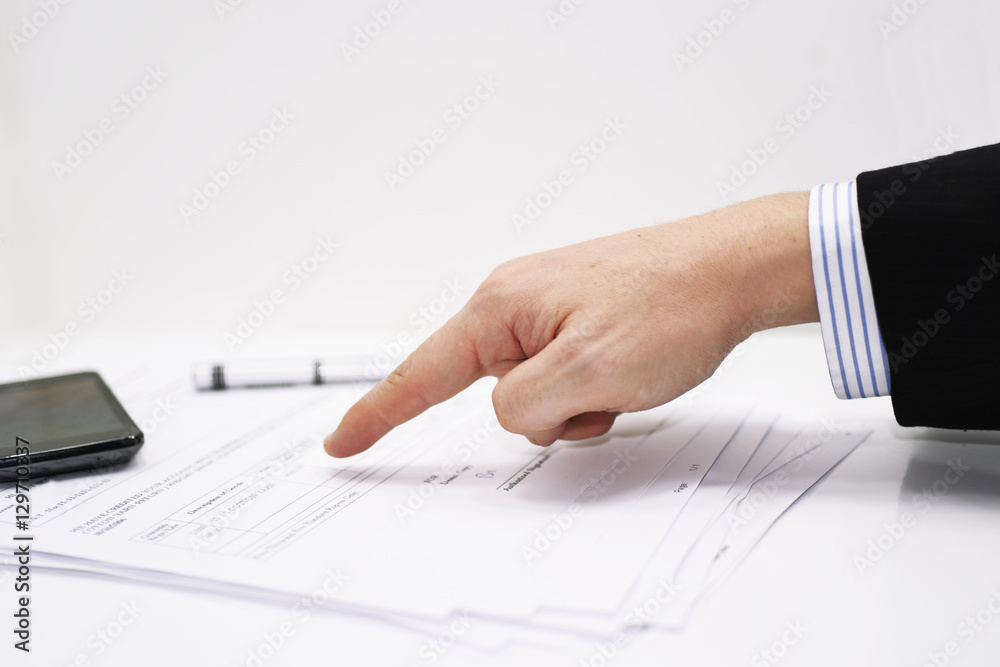 Businessman writes a pen on an tax document Businessman writes a pen on an tax document