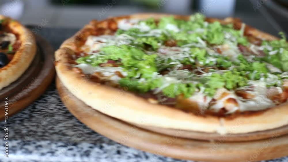 Slider shot of table with 3 pizza in raw Slider shot of table with 3 pizza in raw