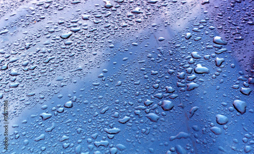 Rain drops on blue metal surface.