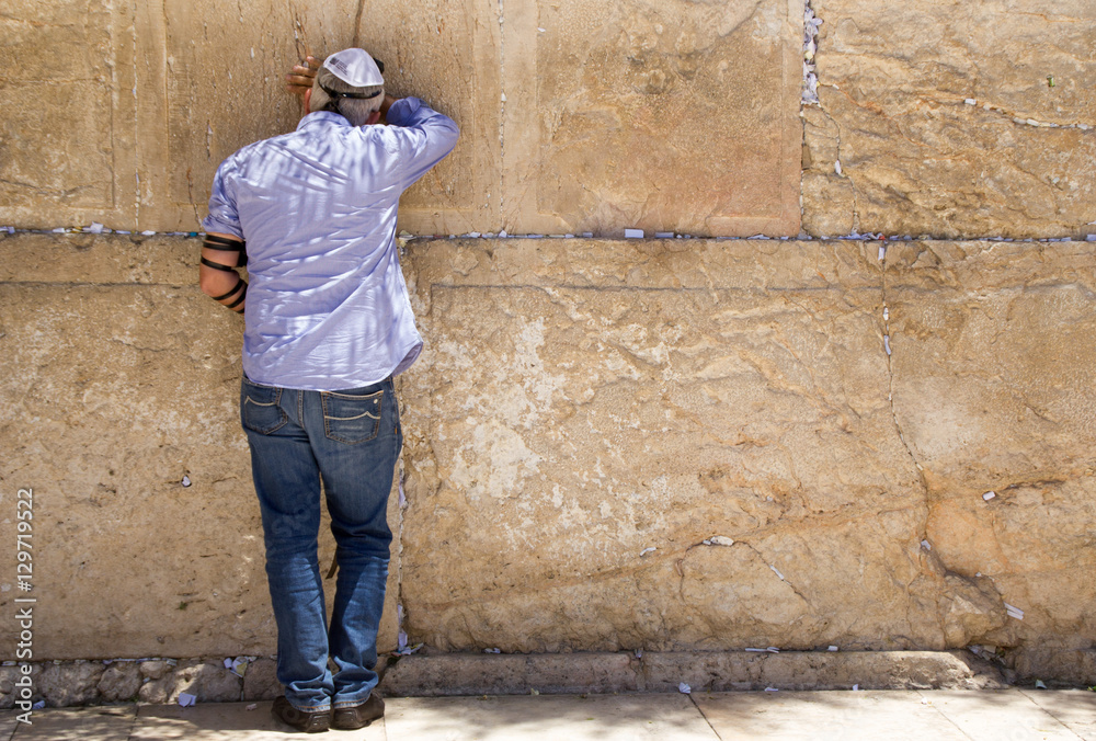 Man with tefillin and jeans is praying at the Wailing Wall, Jerusalem Man with tefillin and jeans is praying at the Wailing Wall, Jerusalem