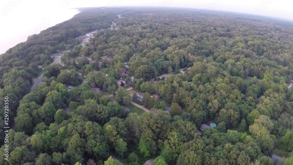 Aerial view looking down on homes in a forest of trees - Travel and leisure concept Aerial view looking down on homes in a forest of trees - Travel and leisure concept