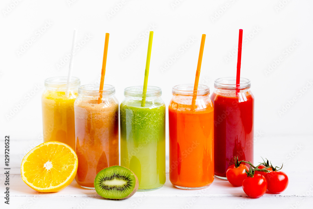 Fresh detox juices in glass bottles on white background Fresh detox juices in glass bottles on white background