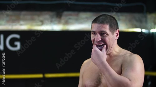 Boxer uses mouthguard before fight HD slow motion close-up video in boxing ring. Teeth mouth protection in combat sport