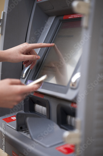 Female hands on the ATM display