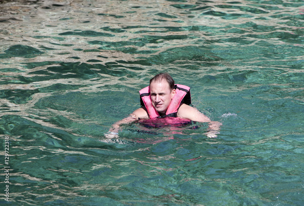 The man in the sea in a life jacket...
