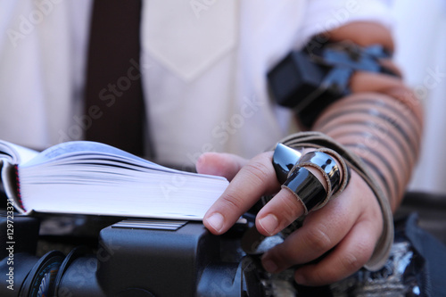 Hand with Tefillin of teenager with book of prayer. Bar Mitzvah Celebration With Tefillin photo