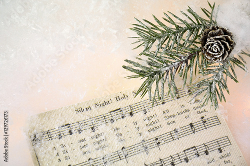 Christmas music and frosted pine in snow with glowing lights photo