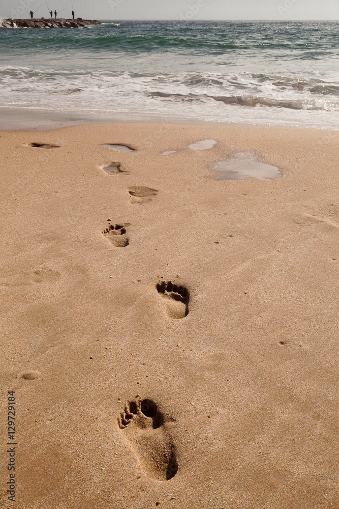 Footprints in the sand, at the beach, Cova do Vapor, Portugal Footprints in the sand, at the beach, Cova do Vapor, Portugal