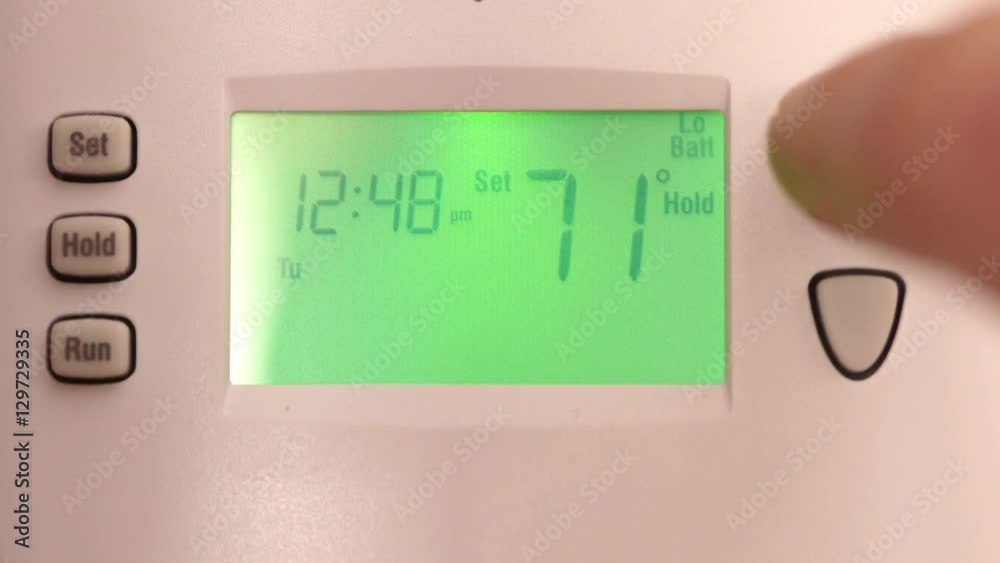 Digital thermostat used for heating and cooling - Energy expense and finance concept Digital thermostat used for heating and cooling - Energy expense and finance concept