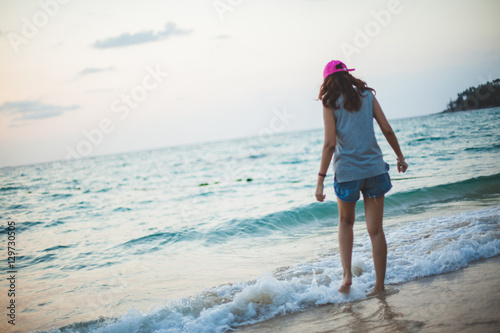 romantic woman from the back in summer vacations on the beach sunset horizontal