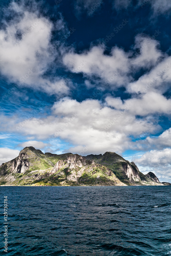 Landscape of a Fjord Norway from the sea with mountain, blue sky and white clouds