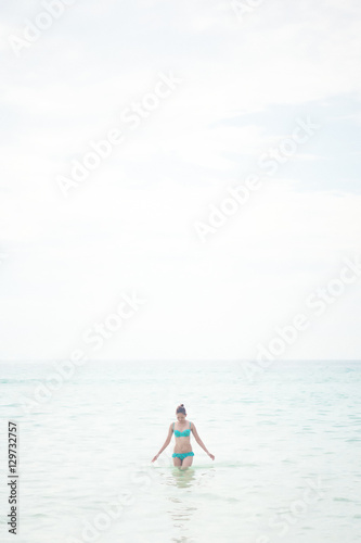 a lady standing at the paradise beach vertical