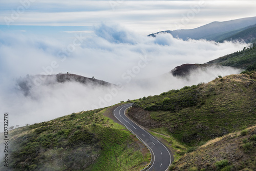 road in mountain landscape over clouds