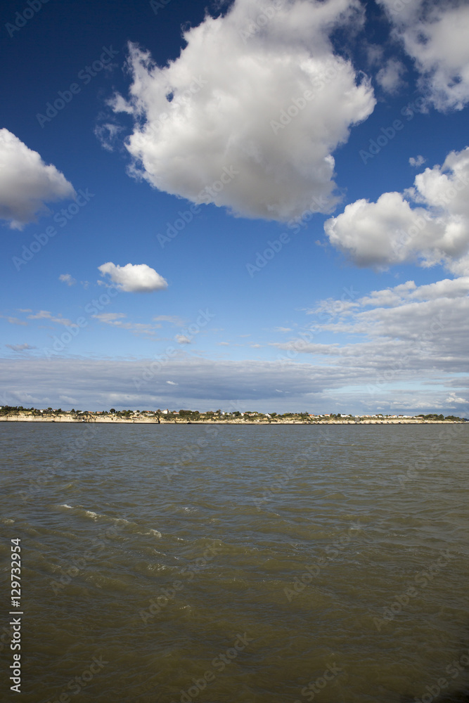 View of the coastline with seaside resort of Royan with blue sky and fluffy white cloud, France