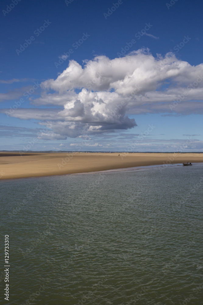 maritime seaside landscape with water, sand bank and white cloud, garonne estuary near Royan, France