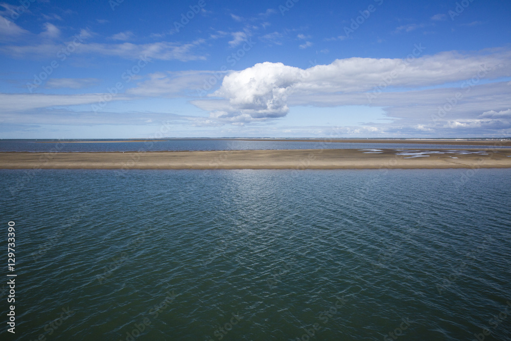 Obraz premium maritime seaside landscape with water, sand bank and white cloud, garonne estuary near Royan, France