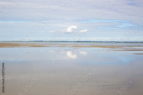 maritime seaside landscape with water, sand bank and white cloud, garonne estuary near Royan, France