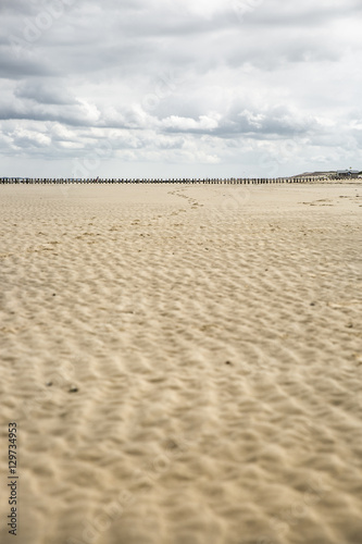 view on a weavy sandy dune with cloudy sky