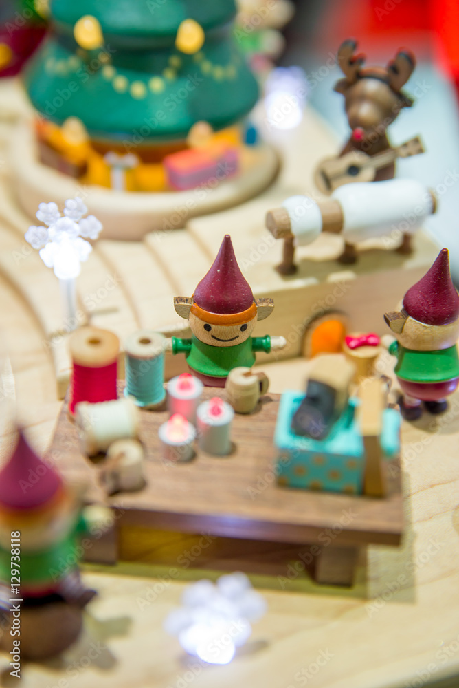 Close-up detail of wooden Christmas toys depicting a scene of elves working in Santa's workshop. Christmas and holidays concept.