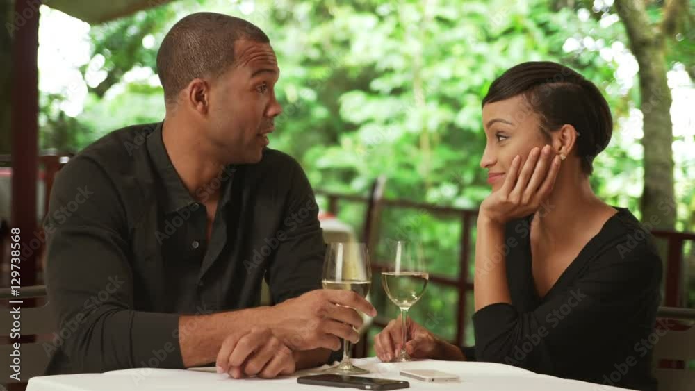 A black couple drink while on a date
