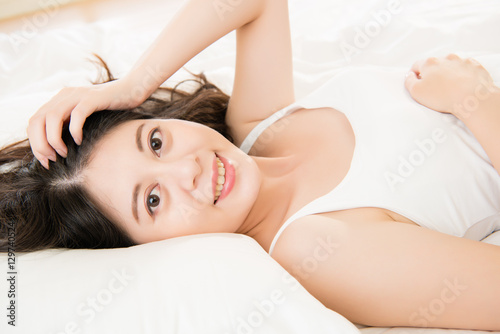 beautiful happy Asian woman lying on bed comfortable and blissfu