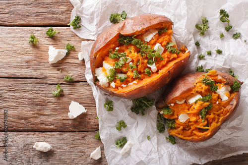 Schilderij op canvas sweet potatoes baked with feta cheese and parsley on the table