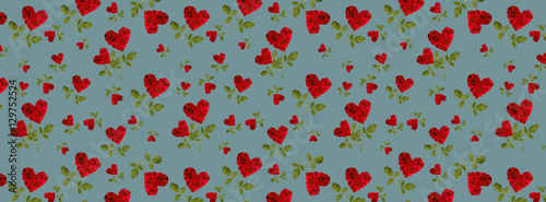 red heart rose petals on a stalk of green leaves