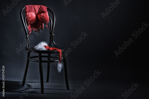 Women's underwear and hat of Santa Claus hanging on a retro chair. Erotic Christmas motif.