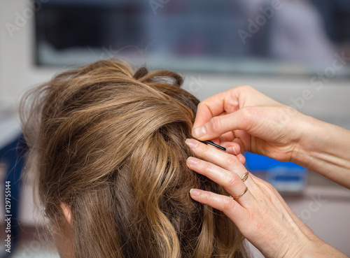 evening hairstyle. Blond doing hairdresser and styling in barber salon