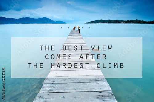 Inspirational motivating quote on long exposure of wooden jetty at sea facing island with cloud and sky at twilight. the best view comes after the hardest climb