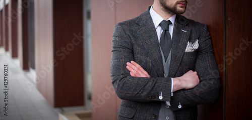Male model in grey suit posing outdoors