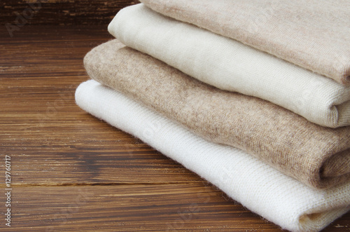 Fotografie Stack of knitted clothes in nude beige tones