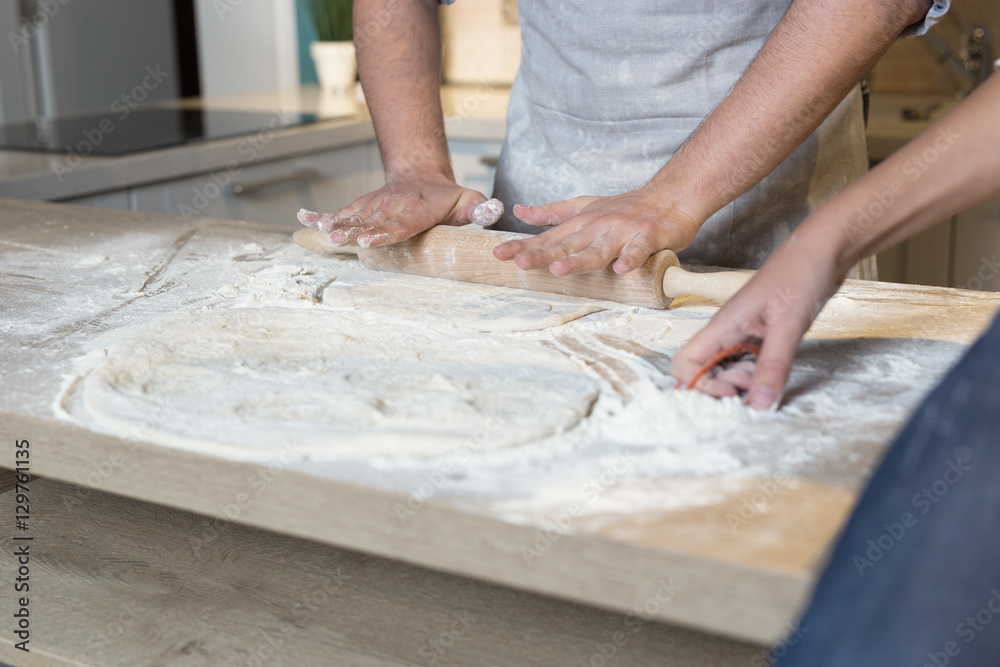 Close up of a father and his son preparing a cake in the kitchen