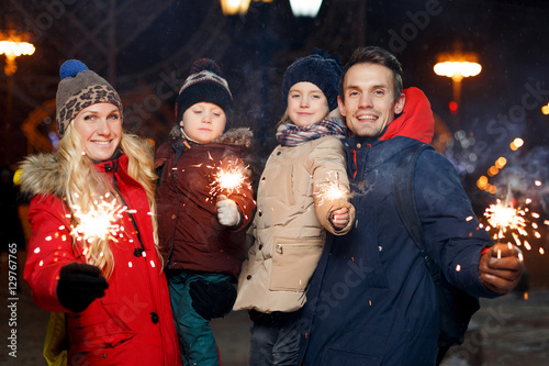 Happy parents with burning sparklers