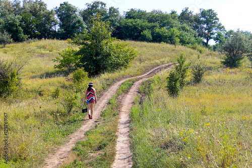 Young girl walking away on the rural road
