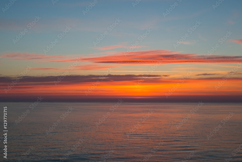Sunset at sea with clouds and horizon