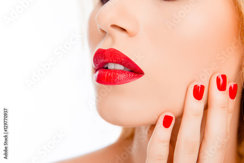 Close up of sexy woman lips with red lipstick and red manicure