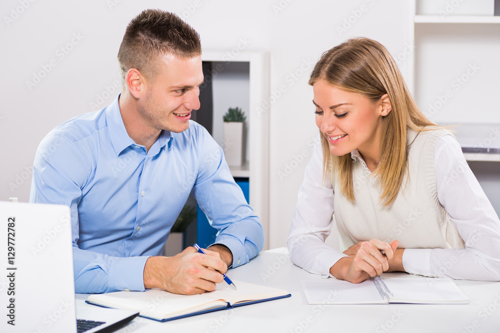 Businesswoman and businessman sitting in office and working together.
Businesswoman and businessman sitting in office and working together.