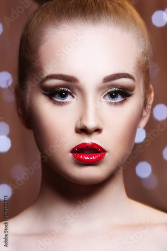 Beauty fashion portrait of a beautiful girl with bright makeup and red lipstick on her lips.