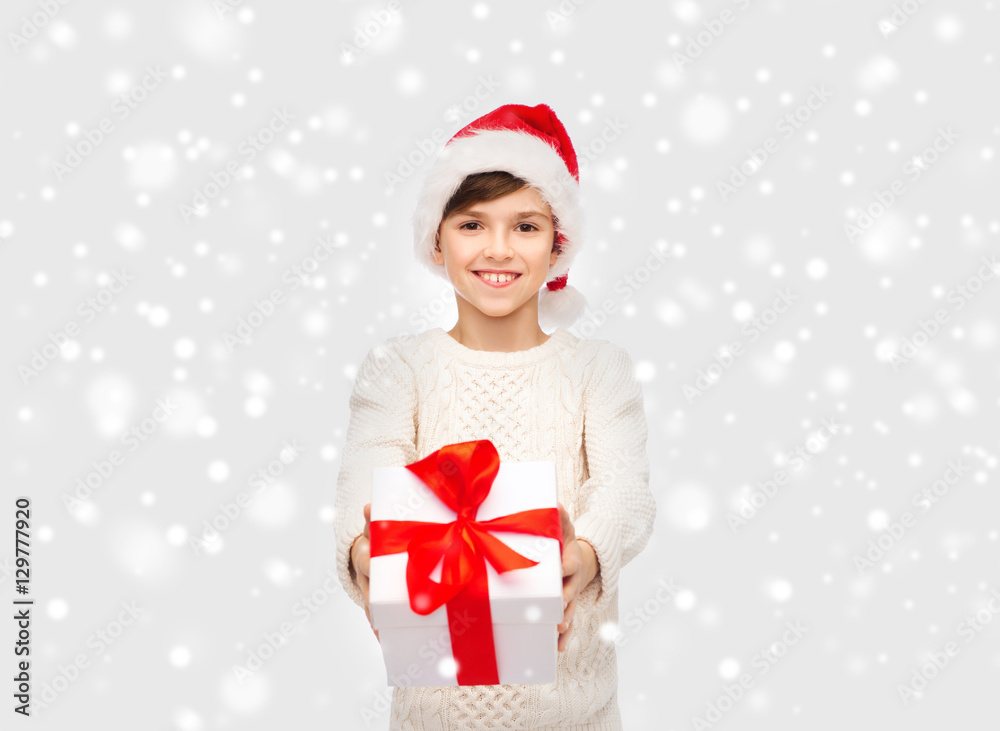 smiling happy boy in santa hat with gift box smiling happy boy in santa hat with gift box