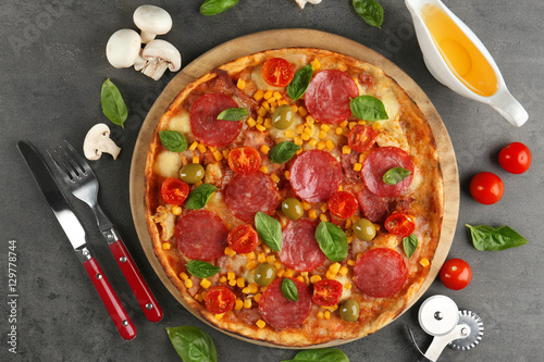Tasty pizza with ingredients on grey table