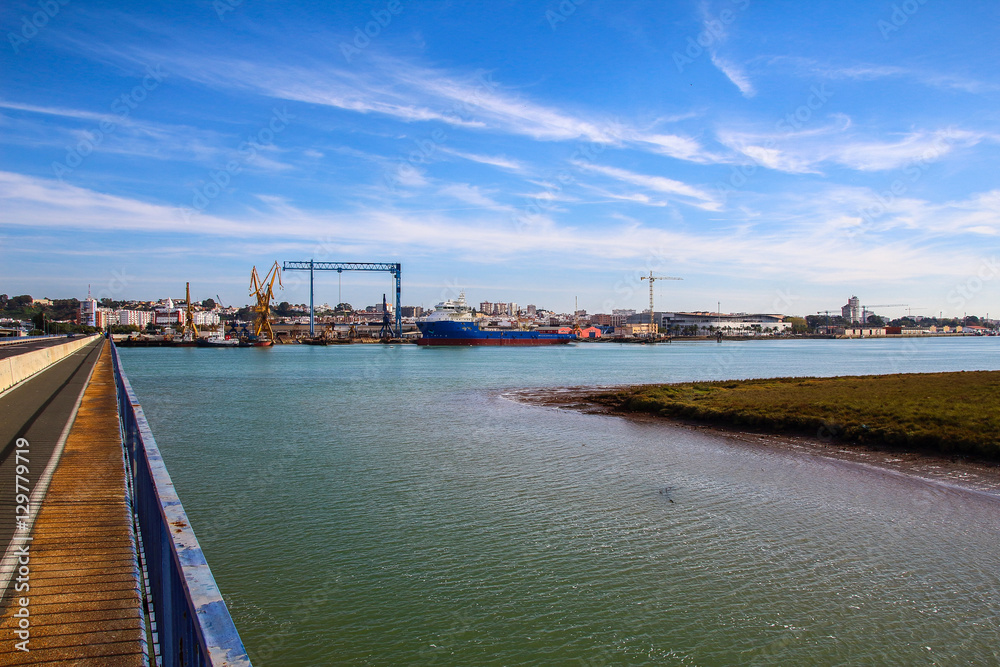 Landscape of port of Huelva with cranes, fishing boat in shipyard and mall in coast of Huelva, Andalusia, Spain.