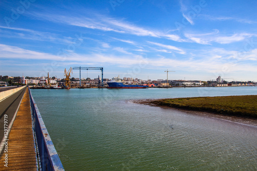 Landscape of port of Huelva with cranes, fishing boat in shipyard and mall in coast of Huelva, Andalusia, Spain.