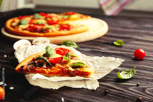 Fresh pizza with tomatoes, cheese and mushrooms on wooden background
