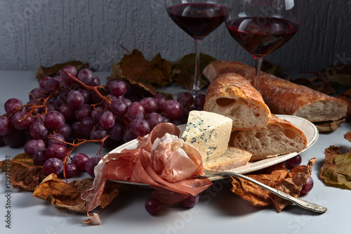 jamon , cheese , grape and red wine on the kitchen table