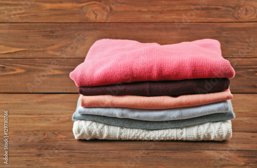 Stack of folded clothes on wooden background
